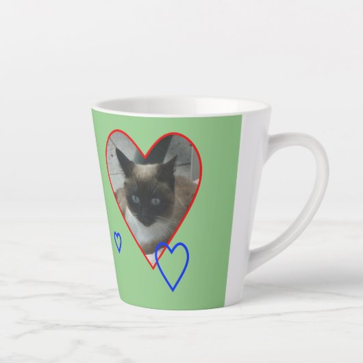 Siamkatze in Herzkruste. Grüne Latte-Tasse Milchtasse (Rechts)