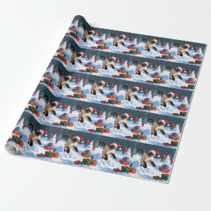 Siamkatze läuft im Schnee mit Weihnachtsmütze Geschenkpapier