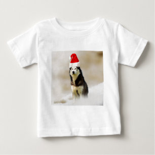 Siberischer Husky-Hund mit Weihnachtsmannmütze im Baby T-shirt