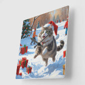Sibirische Katze läuft im Schnee mit Weihnachtsmüt Quadratische Wanduhr (Winkel)