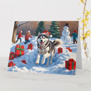 Sibirischer Husky läuft im Schnee mit Weihnachtsmü Karte