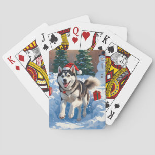 Sibirischer Husky läuft im Schnee mit Weihnachtsmü Spielkarten