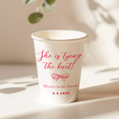 Sie bindet den Knotenknopf an den roten Bogen Pappbecher