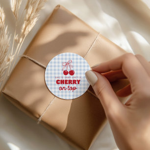 Sie ist unsere Kirsche auf dem blauen Gingham-Gebu Runder Aufkleber