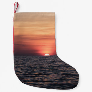 SILHOUETTE DER PERSON AM WASSERKÖRPER WÄHREND DES KLEINER WEIHNACHTSSTRUMPF