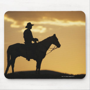 Silhouette des Cowboys auf Pferden bei Sonnenunter Mousepad