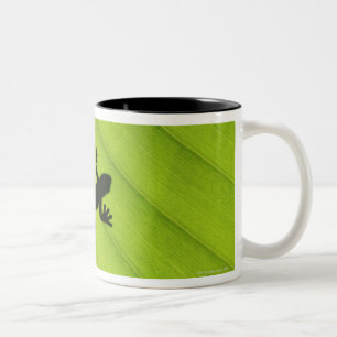 Silhouette des Frosches durch Bananenblatt Zweifarbige Tasse