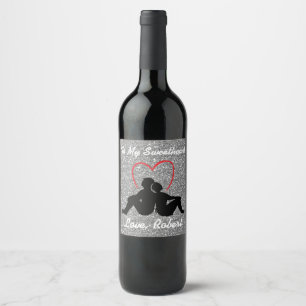 Silhouette-Paare, die rotes Herz-Silber sitzen Weinetikett