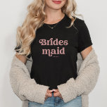 Simple Retro Boho Dusty Rose Typografie Bridesmaid T-Shirt<br><div class="desc">Dieser trendige,  schlichte T - Shirt enthält das Wort "Bridesmaid" in der Retro-staubigen Typografie der Rose,  zusammen mit einem Platz für ihren Namen,  und ist das ideale Geschenk für Mitglieder Ihres Brautparty.</div>