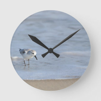Single Sandpiper walking on beach Runde Wanduhr
