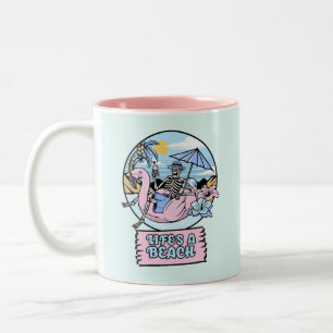 Skelett-Flamingo-Schwimmkörper am Strand des Leben Zweifarbige Tasse