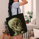 Skelett mit brennender Zigarette | Vincent van Gog Tasche<br><div class="desc">Der Schädel eines Skeletts mit brennender Zigarette (1886) von Vincent van Gogh ist ein auffälliges und unkonventionelles Stillleben-Gemälde mit einem menschlichen Schädel mit einer beleuchteten Zigarette zwischen den Zähnen. Der dunkle Hintergrund verstärkt die Krassigkeit der Skelettfigur, während die kleine Rauchwolke ein Gefühl von Durchgängigkeit und Ironie verleiht. Dieses Kunstwerk, das...</div>