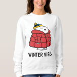 Snoopy Winter in Puffer Coat Sweatshirt<br><div class="desc">This comfortable, long-sleeve sweatshirt features the beloved Snoopy character prominently displayed. The central graphic shows Snoopy dressed warmly for cold weather in a large, puffy red winter coat and a blue and yellow knit cap. Set against a white background, this sweatshirt is a cozy and stylish apparel item, perfect for...</div>