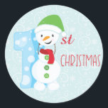 Snowman First Christmas Runder Aufkleber<br><div class="desc">Feiern Sie Ihre ersten Weihnachten mit diesem Aufkleber "Snowman First Christmas" ist ideal für Karten, Geschenke und Handwerk. Mit einem schneeblauen Hintergrund, einem Schneemann Sprichwort "1." und Weihnachten geschrieben in festlich rotem Schriftart. Snowman Sign and Red Christmas Schriftart: Prettygrafik design (https://www.etsy.com/shop/Prettygrafikdesign) Blue Christmas background: Sonya DeHart Design http://www.sonyadehartdesign.com | http://www.sonyadehartdesign.etsy.com...</div>