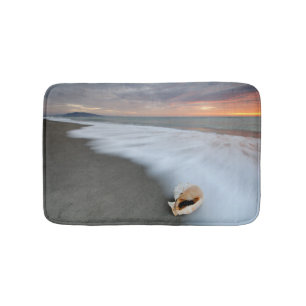 Sonnenaufgang auf dem Strand und einer Muschel Badematte
