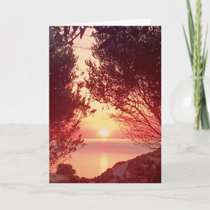 Sonnenaufgang über dem Meer, eingerahmt von Bäumen Karte