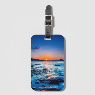 Sonnenaufgang über Horizont an der Küste an der Gepäckanhänger