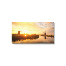 Sonnenaufgang über Windmühlen und einem Fluss in H