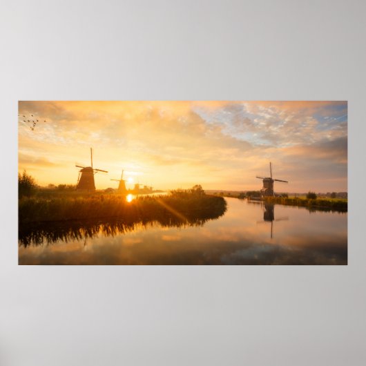 Sonnenaufgang über Windmühlen und einem Fluss in H Poster (Vorne)