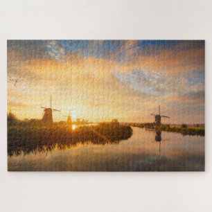 Sonnenaufgang über Windmühlen und einem Fluss in Puzzle