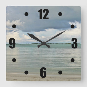 SONNENBRECHEN DURCH DUNKELSTÜCK AM STRAND QUADRATISCHE WANDUHR
