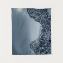 Sonnenlicht und dunkle Wolken über schneebedeckten Wandteppich