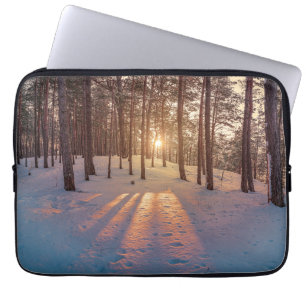 Sonnenuntergang im schneebedeckten Kiefernwald Laptopschutzhülle