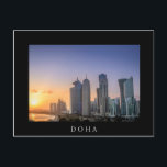 Sonnenuntergang über der Stadt Doha, Katar Postkarte<br><div class="desc">Postkarte eines farbenfrohen Sonnenuntergangs über der Skyline mit den Wolkenkratzern auf der Corniche im Stadtzentrum von Doha,  Hauptstadt des Golf-Landes Katar mit weißer Grenze und der Text: "Doha".</div>
