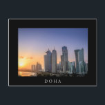 Sonnenuntergang über der Stadt Doha, Katar Postkarte<br><div class="desc">Postkarte eines farbenfrohen Sonnenuntergangs über der Skyline mit den Wolkenkratzern auf der Corniche im Stadtzentrum von Doha,  Hauptstadt des Golf-Landes Katar mit weißer Grenze und der Text: "Doha".</div>