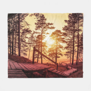 Sonnenuntergang über einem Holzweg im Kiefernwald Fleecedecke