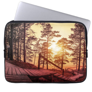 Sonnenuntergang über einem Holzweg im Kiefernwald Laptopschutzhülle