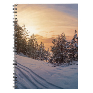 Sonnenuntergang über gefrorenem Schneewald in der  Notizblock