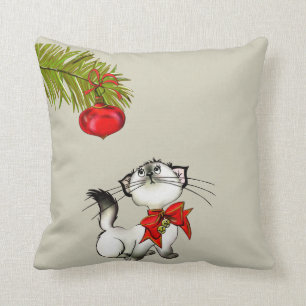 Spielvolle Kätzchen in einem roten Weihnachtsbock Kissen