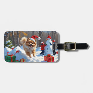 Spitz läuft im Schnee mit Weihnachtshut Gepäckanhänger