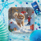Spitz läuft im Schnee mit Weihnachtshut Pappteller (Party)