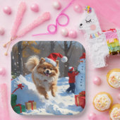 Spitz läuft im Schnee mit Weihnachtshut Pappteller (Party)