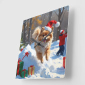 Spitz läuft im Schnee mit Weihnachtshut Quadratische Wanduhr (Winkel)