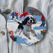 Springer Spaniel läuft durch Schnee mit Weihnachts Button (Beispiel)