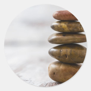 Stapel der Dunkelheit färbte Steine auf weißem Runder Aufkleber