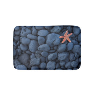 Starfish auf schwarzen Felsen entlang der Küste Badematte