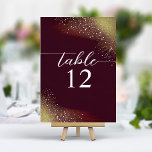 Starry Night Deep Crimson Wedding Tischnummer<br><div class="desc">Die 'Starry Night Deep Crimson Wedding Tischnummer' ist eine elegante navigative Touch zu Ihrem Hochzeitsdekor. Die Karte weist einen reichen, tiefen Hintergrund auf, der an eine leuchtende goldene Farbe erinnert, die an einen Sternenhimmel erinnert, der in den Morgengrauen übergeht. Eine Konstellation von zarten goldenen Flecken verstreut über die Decke und...</div>