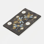 Steampunkdrachenfliegen auf braunem, gestreiften H Post-it Klebezettel (angewinkelt)