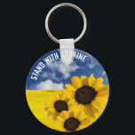 Stehen Sie mit der Ukraine gelb und blau mit Sonne Schlüsselanhänger<br><div class="desc">Stehen Sie mit der Ukraine. Blauer Himmel und gelbe Felder, die die ukrainische Fahne darstellen, Sonnenblumen, die die nationale Blume und Entschlossenheit des ukrainischen Volkes darstellen. Wenn Sie hassen, was vor sich geht, dann ist hier eine Möglichkeit, das auszudrücken. Sie können den Text anpassen. Originelles grafisches Design mit originalen Fotografien...</div>