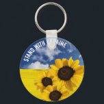 Stehen Sie mit der Ukraine gelb und blau mit Sonne Schlüsselanhänger<br><div class="desc">Stehen Sie mit der Ukraine. Blauer Himmel und gelbe Felder, die die ukrainische Fahne darstellen, Sonnenblumen, die die nationale Blume und Entschlossenheit des ukrainischen Volkes darstellen. Wenn Sie hassen, was vor sich geht, dann ist hier eine Möglichkeit, das auszudrücken. Sie können den Text anpassen. Originelles grafisches Design mit originalen Fotografien...</div>