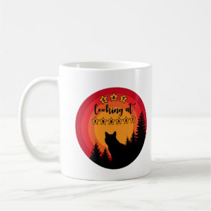Stehende schwarze Katze schaut auf Sonnenuntergang Kaffeetasse