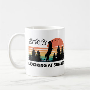 Stehende schwarze Katze schaut auf Sonnenuntergang Kaffeetasse