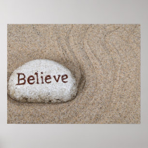 Stein im Sand mit dem Wort Believe Poster