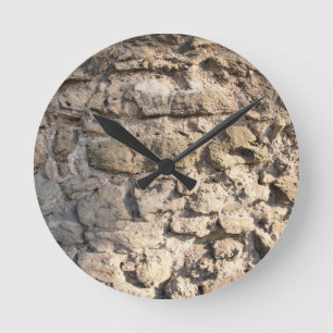 Steinmauer aus großen rauhen grauen Steinen Runde Wanduhr