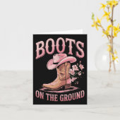 Stiefel auf dem schwarzen Western am Boden, wo die Karte (Gelbe Blume)