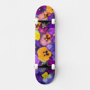 Stiefmütterchenblüten schwimmend im Vogelbad mit T Skateboard